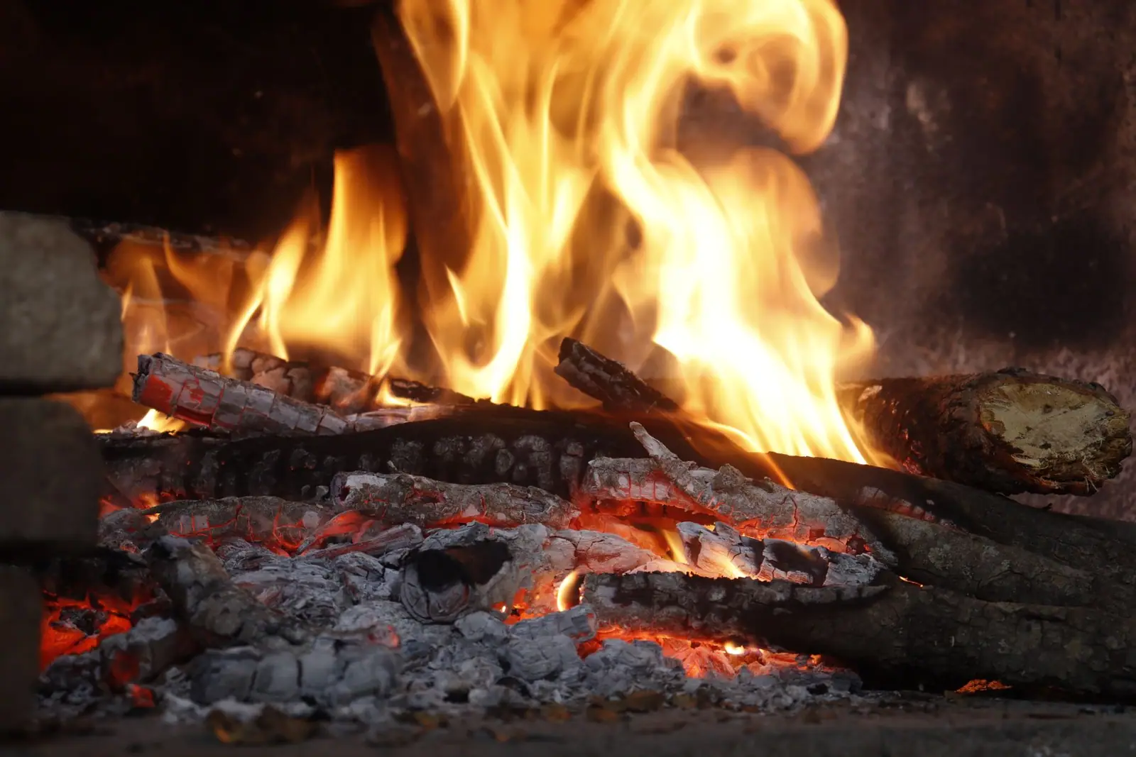 Flames rising over glowing coals inside a firebox
