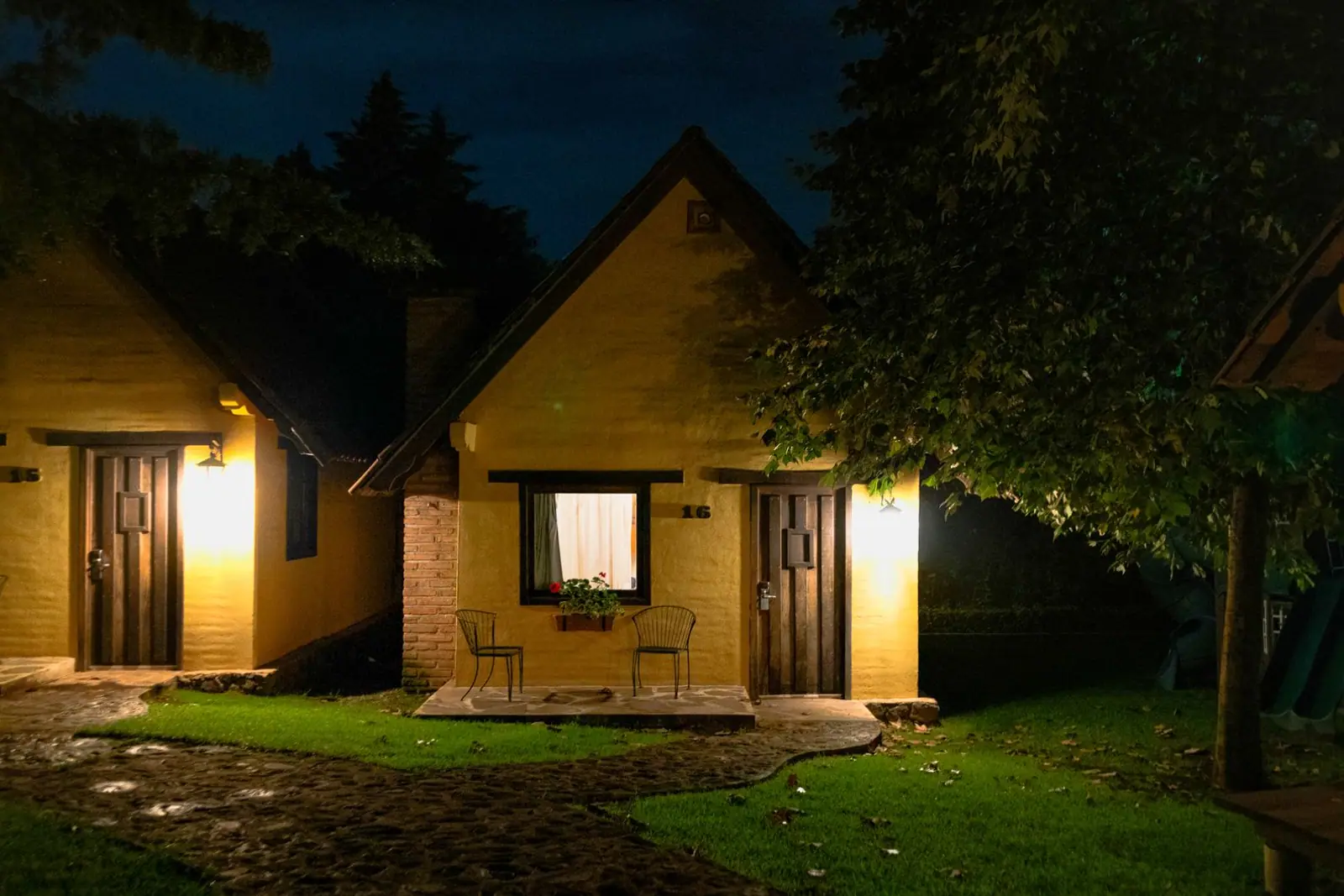 Cottages with their windows and porches lit at twilight