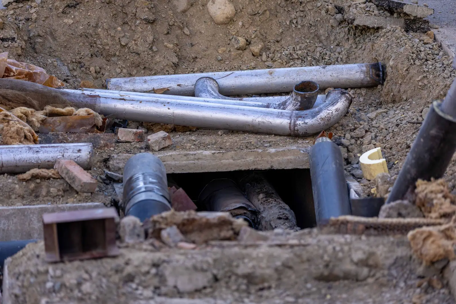 Pipes and materials at an open excavation on a street