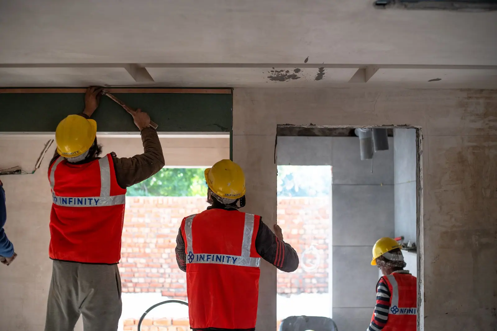 Workers fitting out an opening in a house wall